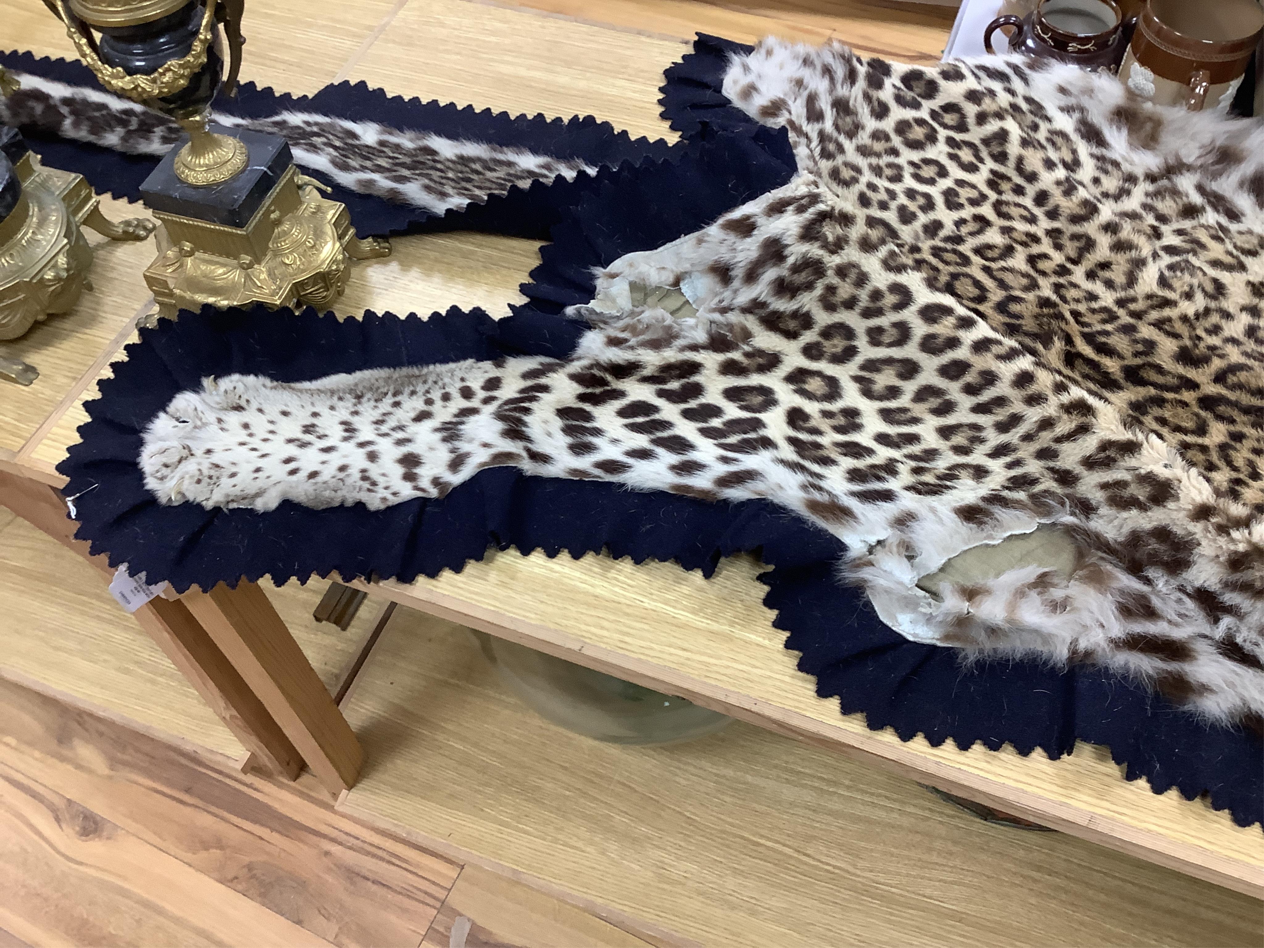 An early 20th century leopard skin rug with taxidermy head by van Ingen and van Ingen, Mysore, makers name stamped to the back, 215cm long. Condition - poor